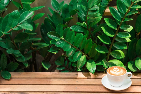 Ahşap masada beyaz fincan latte sanat doku kahve