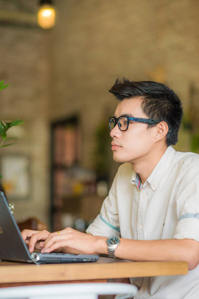 Business asian men working with laptop in coffee shop