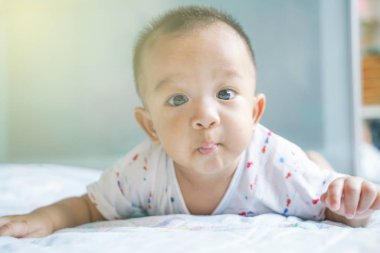 Komik bebek çocuk yatak odasında battaniye üzerinde sürünen