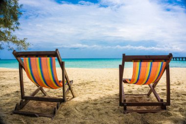 Beyaz kumlu plajda renkli plaj sandalyesi