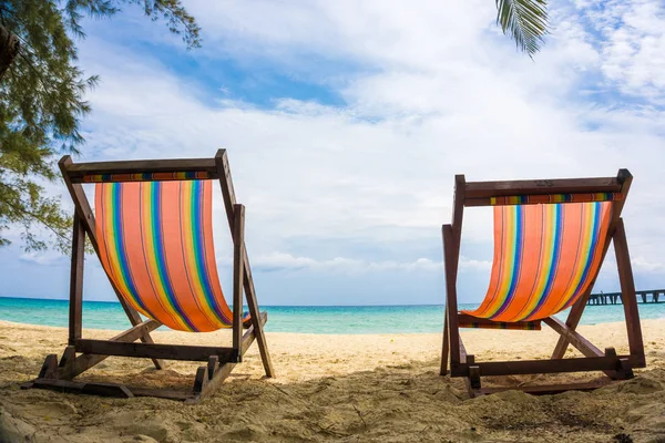 Beyaz kumlu plajda renkli plaj sandalyesi