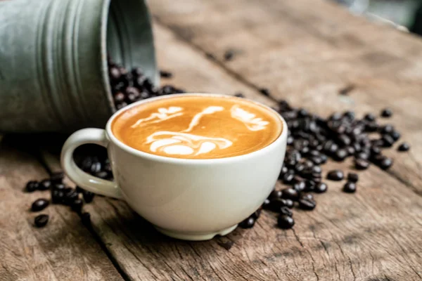 Latte art kávé fehér csésze sült bab — Stock Fotó