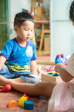 Asya sevimli küçük çocuklar üzerinde otururken oyuncak kutusu ile oynarken