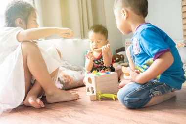 Asya sevimli küçük çocuklar üzerinde otururken oyuncak kutusu ile oynarken