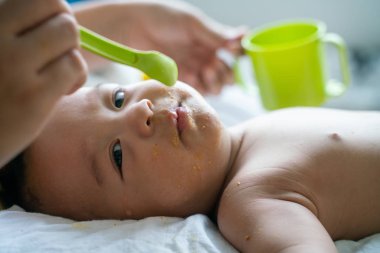 Toddler çocuk çocuk anne eliyle pap gıda yemeye çalışın