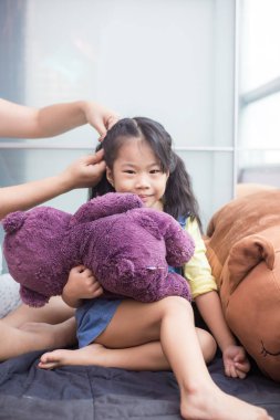 Anne bebek ile kızının saç stili yapıyor