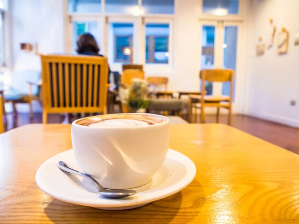 Heißer Latte-Art-Kaffee in weißer Tasse auf Holztisch — Stockfoto