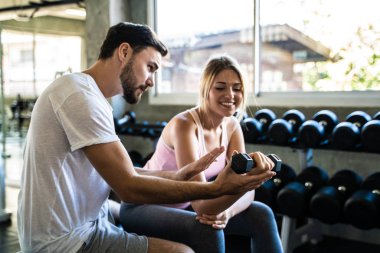 Spor salonunda antrenörle antrenman yapan beyaz kadınlar.