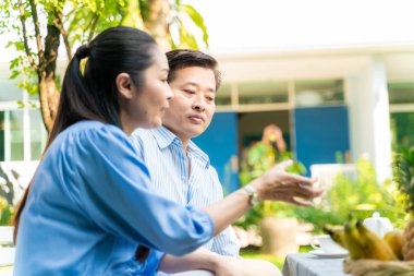 Asyalı çift parkta rahatlıyor.