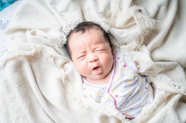 Yeni doğmuş erkek bebek pamuklu battaniyede uyuyor.