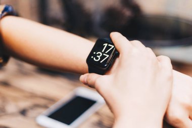 Kadınlar kafede otururken akıllı saat takarlar.