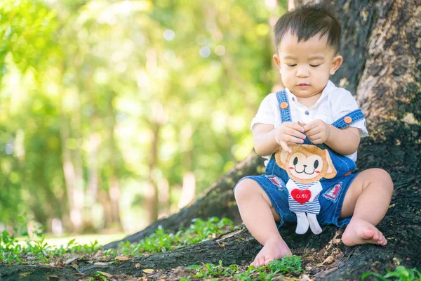 Bebek oğlan yeşil çayır şehir parkında oynuyor. — Stok fotoğraf