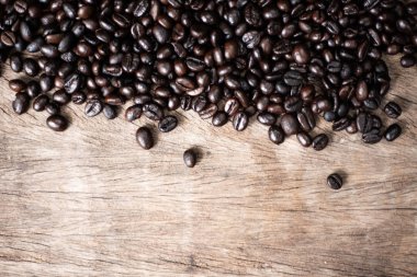 Ahşap arka planda kavrulmuş kahve çekirdeği.