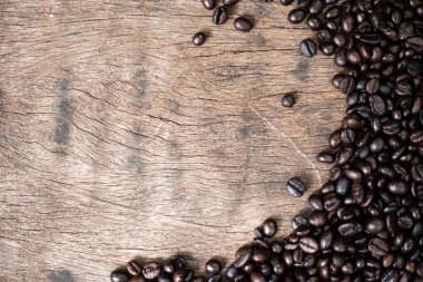 Ahşap arka planda kavrulmuş kahve çekirdeği.