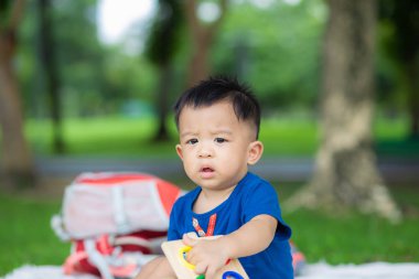Bebek çocuk piknik paspasında yeşil çimlerde sürünüyor