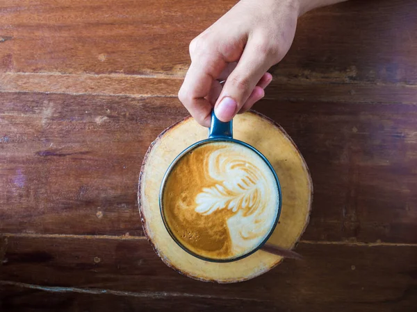 Kezében forró latte art kávéscsésze — Stock Fotó