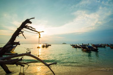 Deniz sahili, sabah güneşi, renkli gökyüzü.