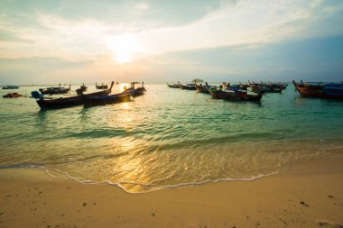 Deniz sahili, sabah güneşi, renkli gökyüzü.