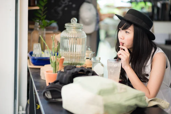 Студентки азиатского происхождения сидят в кафе и пьют кофе. — стоковое фото
