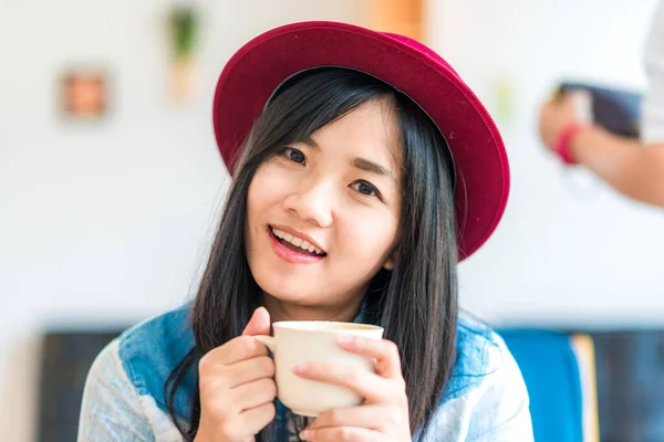 美丽的亚洲女人在咖啡店里拿着热咖啡杯 — 图库照片