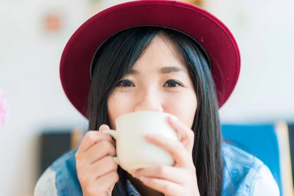 Beautiful asian women hold hot coffee cup in cafe