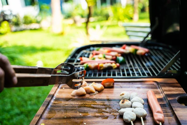 Churrasco festa grelhada no jardim ao ar livre mão de perto — Fotografia de Stock