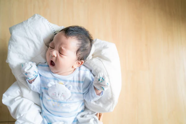 Schattige baby liggend in houten mandje met deken — Stockfoto