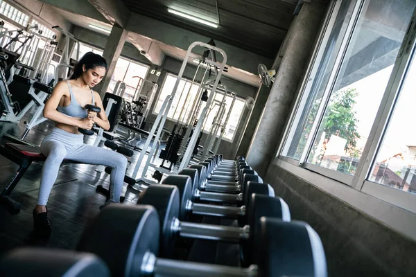 Healthy fitness women lifting dumbbell weight in gym — ストック写真