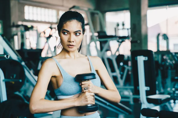 Healthy fitness women lifting dumbbell weight in gym — Stock fotografie