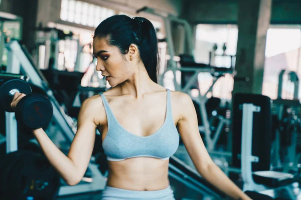 Healthy fitness women lifting dumbbell weight in gym — Stock fotografie