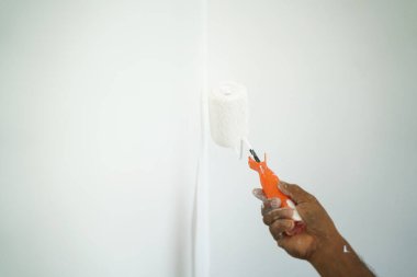 Ev boyası duvarın içinde, el yuvarlanıyor.