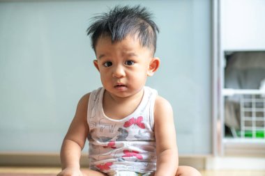 Sevimli küçük çocuk odada oturuyor.