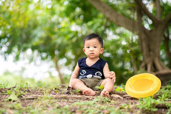 Sarı şapkalı çocuk yeşil şehir parkında seyahat ediyor. — Stok fotoğraf