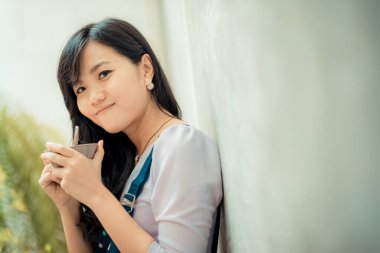 Güzel Asyalı kadınlar sıcak sütlü kahve içerler.