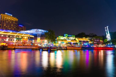 Singapur - 5 Mart 2015 gecesi Clarke Quay, Singapur 'da renkli ışık binası. Clarke Quay, Singapur 'un Singapur Nehri bölgesinde tarihi bir nehir kenarı rıhtımıdır..
