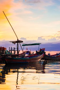 Deniz sahilinde gün batımı silueti. Bulutlu renkli gökyüzü.