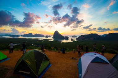 Dağ tepesinde kamp çadırı. Gün doğumu deniz koyunda.