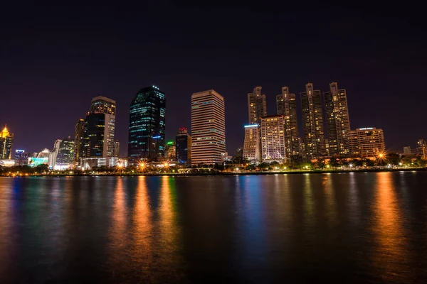 Modern building light with pond public park at night, Bangkok Thailand