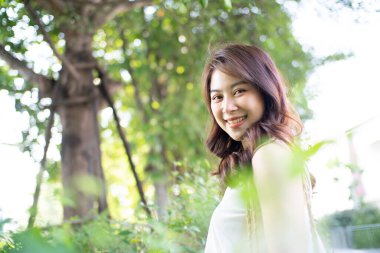 Asyalı kadınların yeşil şehir parkında boş vakitlerinde çekilmiş güzel bir yüz ifadesi.