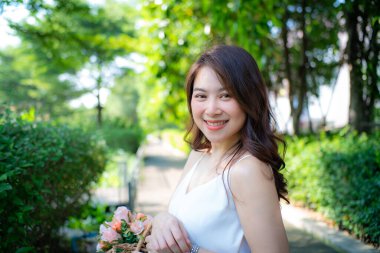 Asyalı kadınların yeşil şehir parkında boş vakitlerinde çekilmiş güzel bir yüz ifadesi.