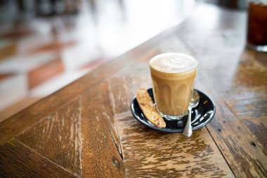 Kafedeki ahşap masada kahve içerken bir bardak sıcak kahve.