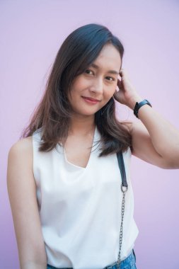 Moda Asyalı kadınlar pembe arka planda gülümseyen uzun saçlı kadınlar.