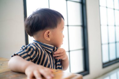 Sevimli, komik çocuk oturma odasında tahta kutuyla ayakta durmaya çalış.