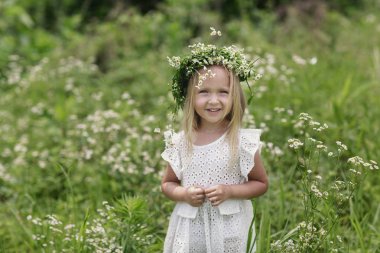 Parlak bir yaz gününde yürüyüşe çıkarken. Kafasında chamomiles bir çelenk ile küçük bir kızın portresi