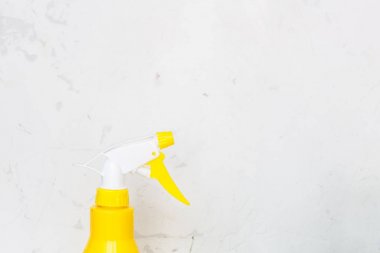 Gri arka plan üzerinde basit sarı plastik el spreyi şişesi.