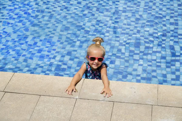 Menina feliz na piscina ao ar livre no dia quente de verão. As crianças aprendem a nadar. As crianças brincam em resort tropical. Família praia férias . — Fotografia de Stock