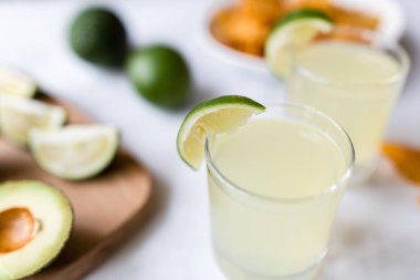 Taze avokado, kireç, içecek ve mermer arka plan üzerinde yatan nacho cips. Cinco de Mayo parti tarifi