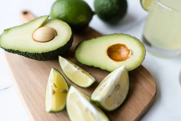 Fresh avocado, lime, drink and nacho chips lying on marble background. Recipe for Cinco de Mayo party — Stock Photo, Image