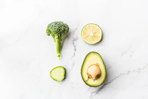 Frische Avocado, Limette, Brokkoli, grüne Erbsen, Gurken, grüner Pfeffer. flach lag. Food-Konzept. grünes Gemüse liegt auf weißem Marmor Hintergrund — Stockfoto