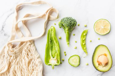 Taze avokado, limon, brokoli, bezelye, salatalık, yeşil biber. Düz yatıyordu. Gıda konsepti. Beyaz mermer arka plan üzerinde yatan yeşil sebzeler